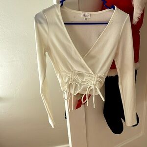 A white deep v top with scrunching on the bottom, it’s the brand LELIS size xs